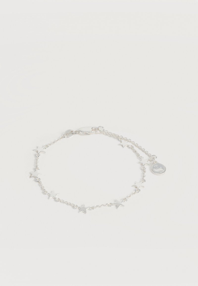 Λεπτό ασημένιο βραχιόλι με μικρά αστέρια-σχήματος κρεμαστά διακοσμητικά και στρογγυλή ετικέτα κοντά στο κούμπωμα τύπου «καβουράκι».