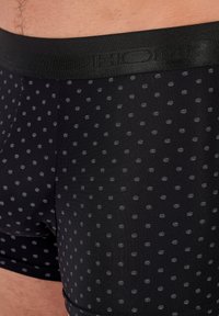 Boxer shorts neri con un motivo decorativo che presenta piccole macchie grigie. La vita è elastica e riportata con il nome del marchio in nero.