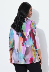 Buntes Oberteil mit abstrakten Aquarellmustern in lila, pink, blau und orange; verfügt über dreiviertellange Ärmel und einen lockeren Schnitt.
