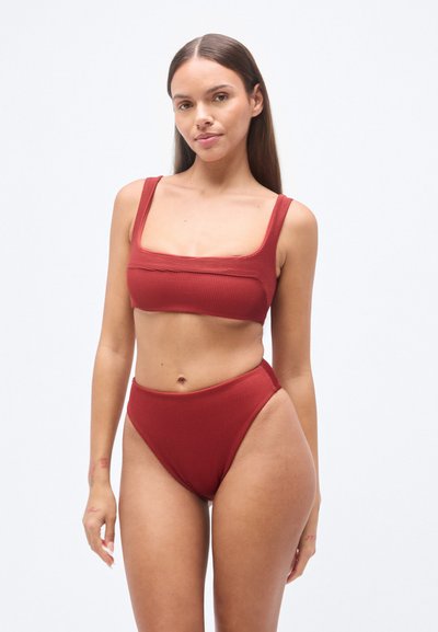 Σετ μπικίνι μπορντό με ριμπ ύφανση, που περιλαμβάνει τοπ με τετράγωνη λαιμόκοψη και σλιπ ψηλόμεσο. Λείο ύφασμα με φαρδιές τιράντες και πλαϊνές ανοίγματα.
