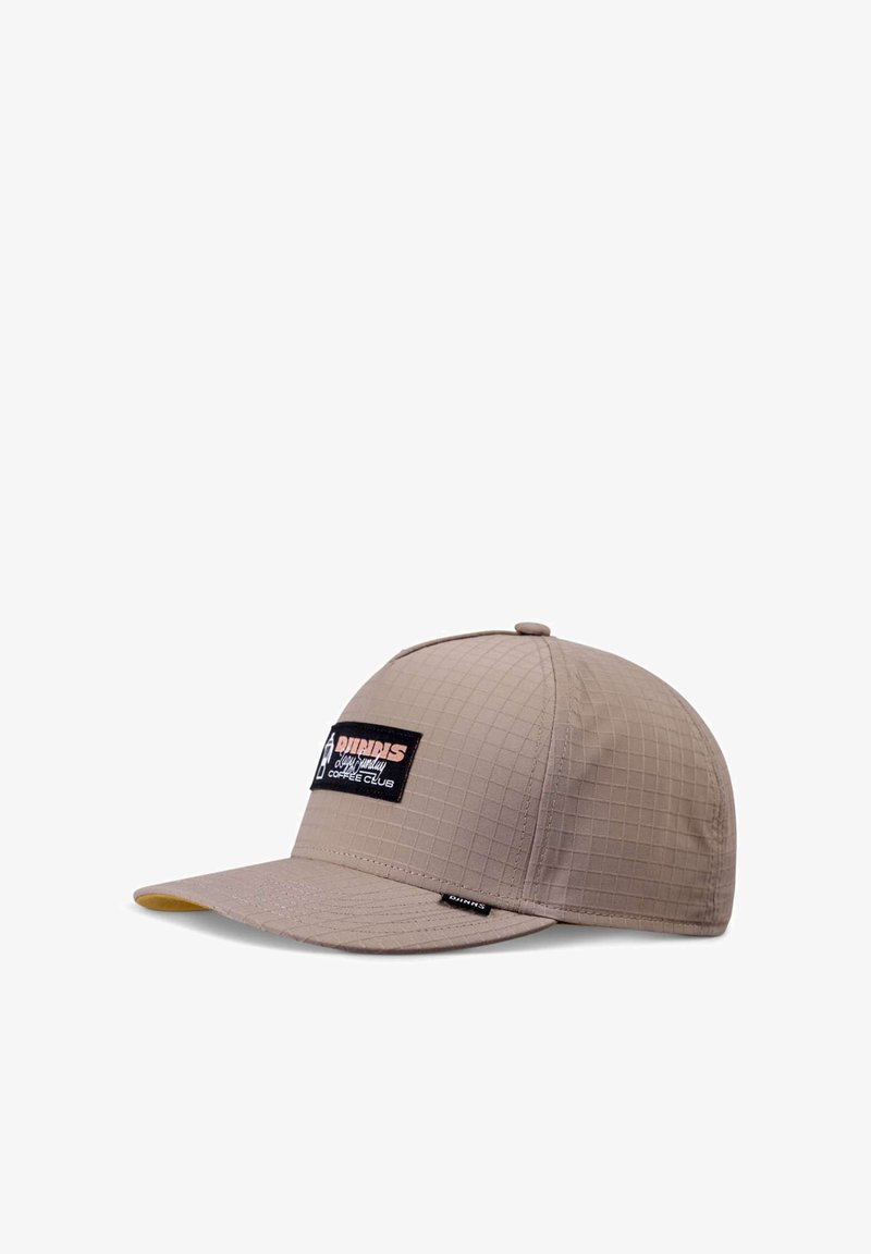 Beige cap with a checkered texture, flat brim, and a black logo patch featuring white and red text on the front left side.
