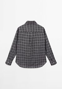 Chemise à manches longues à carreaux noirs et gris avec poignets boutonnés, vue de dos sur fond blanc.