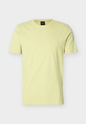 T-shirt à manches courtes de couleur jaune clair avec un logo en relief subtil sur la poitrine et une étiquette noire à l'intérieur du col portant le texte orange "BOSS".