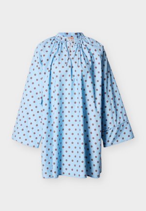 Ανοιχτό μπλε μπλούζα με μακριά μανίκια και καστανές βούλες, με σούρα στον λαιμό και κορδόνι, καθώς και φαρδιά μανσέτα, σε λευκό φόντο.