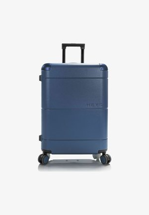 Valigia rigida di colore blu navy, con una superficie liscia, manico retrattile e quattro ruote multidirezionali per una facile mobilità.