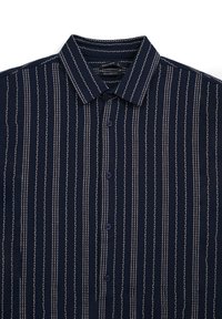 Camicia button-up blu navy con tessuto testurizzato caratterizzato da righe verticali grigio chiaro e dettagli ondulati. Collo standard e design di vestibilità rilassata.