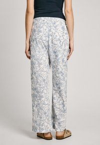 Pantalons fluides à motif floral en blanc et bleu clair, dotés d'une taille élastique et de jambes larges. Le matériau semble léger.