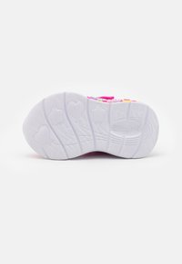Buty Skechers z białą gumową podeszwą, zdobione wzorami serc i gwiazdek. Podeszwa jest teksturowana, aby zapewnić lepszą przyczepność, a górna część butów ma różowe akcenty.