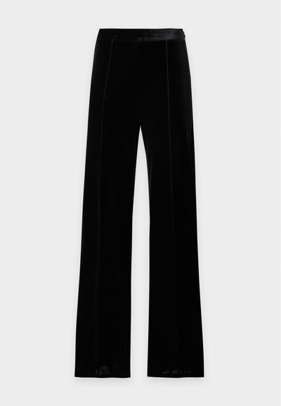Pantalon large en velours noir taille haute, avec une ceinture lisse et des coutures discrètes à l'avant.