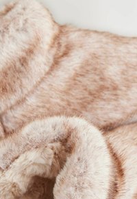 Faux-Fur-Stoff in Hellbraun mit einer weichen, strukturierten Oberfläche. Das Material weist subtile Farb- und Längenvariationen auf, die für zusätzliche Tiefe sorgen.