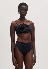 Zwart bikini set met een bandeau top met een grote ruffelbloemdetail en een hooggetailleerde onderkant. Glad materiaal met dunne bandjes.