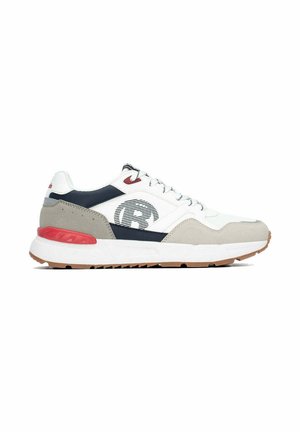 Zapatilla baja blanca y beige con detalles en negro y rojo, puntera redonda, cordones en la parte delantera y logo estampado en el lateral.