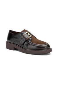 Zapato de cuero negro con un panel de piel de color marrón, acentos de doble hebilla dorada, puntera redonda y suela baja de goma marrón.