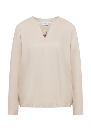 Beige pitkähiha paita V-pääntiellä, joustavalla helmalla ja sileällä tekstuurilla. Merkissä lukee "CECIL." Yksinkertainen muotoilu ilman kuvioita tai yksityiskohtia.