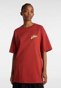 Camiseta de algodón roja con un corte holgado, mangas cortas y un logo amarillo de "Vans" en el lado izquierdo del pecho. Textura suave con un cuello redondo clásico.