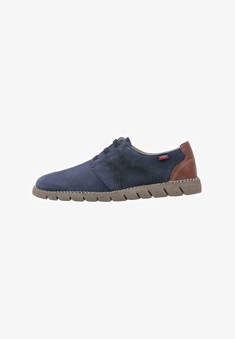 Zapatos casuales para hombre en ante azul marino con detalles en cuero marrón. Diseño perforado, suela de goma con agarre texturizado y cierre con cordones.