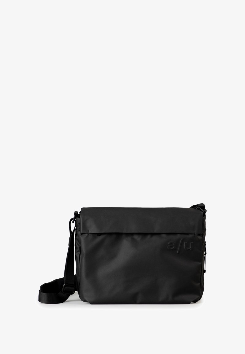 Borsa a tracolla nera realizzata in materiale resistente con una superficie liscia, dotata di una patta pieghevole, tracolla regolabile e un marchio discreto.