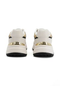 Baskets blanches avec des accents dorés et des détails noirs. Semelle rembourrée, tige en cuir lisse, et un détail métallique de marque sur le talon.