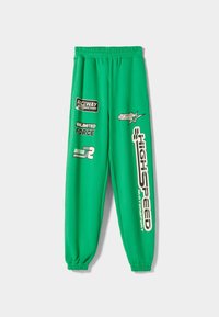 Grüne Sweatpants mit einem elastischen Bund. Verfügt über mehrere grafische Drucke in Schwarz und Weiß, darunter "Highspeed" und "Unlimited Force."