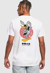White cotton t-shirt featuring a graphic of a cartoon duck in a gray hoodie, with red circular design and Chinese text, "The Year of the Rabbit."