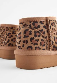 Stivaletti marroni alla caviglia realizzati in materiale morbido, con un motivo animalier a macchie, lati testurizzati e suola in gomma dal design leggero.