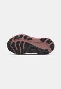 Semelle de chaussure avec un relief en caoutchouc noir texturé et un rembourrage rose. Design incurvé avec des motifs variés pour une adhérence et un soutien.