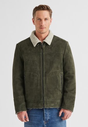 Olivgrüne Kunstlederjacke mit einem weichen, cremefarbenen Lammfellkragen. Verfügt über Reißverschluss-Taschen und ein strukturiertes Design.
