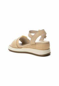 Sandali con zeppa beige caratterizzati da una tomaia in tessuto intrecciato, fasce incrociate e una suola platform bianca con fondo in gomma per una migliore aderenza.