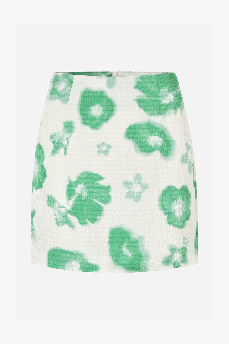 Fustă mini florală albă cu modele de flori verzi, realizată dintr-un material texturat. Dispune de un fermoar ascuns la spate și are o siluetă ajustată.