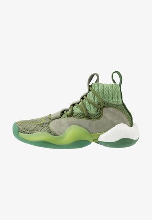 Green athletic shoe featuring a mix of textured mesh and suede materials, a rounded sole, and a unique knit collar for support.