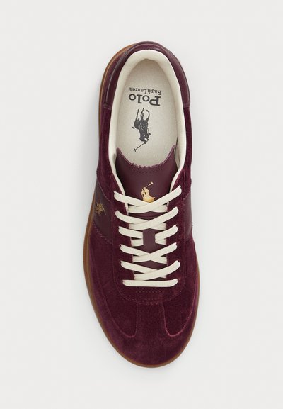 Men's burgundy suede sneaker with cream laces, tan sole, and Polo Ralph Lauren logo on tongue and side.