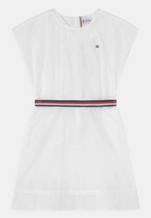 Robe blanche à manches courtes avec col rond, taille élastique avec des rayures rouges, blanches et bleues, et petit logo sur la poitrine.