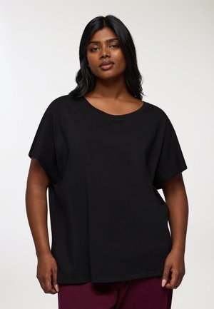 T-shirt nera oversize realizzata in cotone morbido, con scollatura rotonda e maniche corte. Texture liscia senza modelli o accenti visibili.