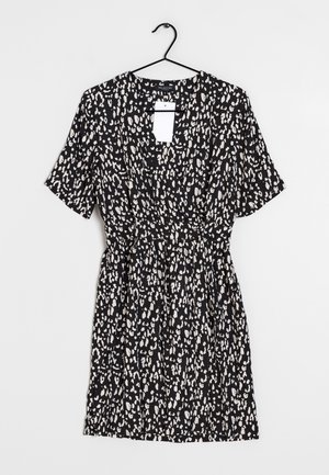 Vestido negro con mangas cortas, con un patrón abstracto en blanco y beige. Cintura elástica, escote en V y etiqueta colgante visible.