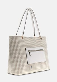 Sac fourre-tout tissé beige avec des accents en fausse cuir blanc, poche avant zippée, doubles poignées et motif croisé subtil.