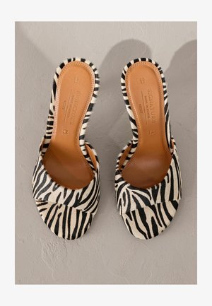 Zebramuster-Sandalen mit einem weichen, strukturierten Obermaterial und einer braunen Leder-Innensohle. Runde offene Zehenpartie mit einem breiten Riemendesign.