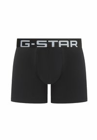 Schwarze Herrenboxershorts mit einem grauen elastischen Bund, der den Markennamen "G-STAR" in großen Großbuchstaben trägt.