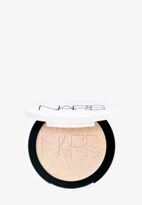 NARS Highlighter in einem runden Kompakt mit einem weißen Deckel und schwarzem Boden, der einen schimmernden goldenen Champagner-Ton mit durchgeprägten Logo-Details zeigt.