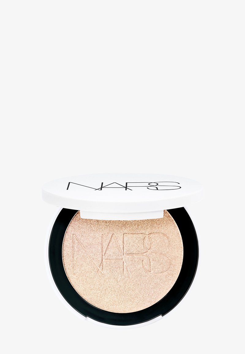 NARS Highlighter in einem runden Kompakt mit einem weißen Deckel und schwarzem Boden, der einen schimmernden goldenen Champagner-Ton mit durchgeprägten Logo-Details zeigt.