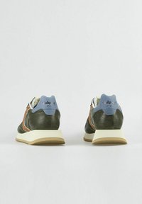 Las zapatillas cuentan con una parte superior de cuero verde con acentos marrones, un talón azul claro y una suela color crema. El diseño incluye un acabado texturizado.