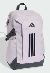 Mochila de tela color púrpura claro con detalles en negro, que cuenta con un logo frontal y tres franjas verticales. Incluye bolsillos laterales y correas ajustables.