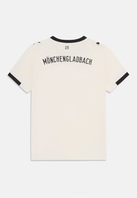 Bijela majica kratkih rukava s natpisom "MÖNCHENGLADBACH" otisnutim u crnoj boji na leđima. Crni detalji na rukavima i ovratniku.