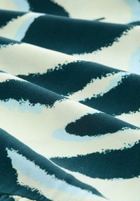 Tekstura tkanine s apstraktnim uzorkom u tamnozelenoj, svjetloplavoj i krem boji; meki, fluidni izgled s valovitima uzorcima.