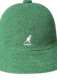 Grüner Frotteehut mit weicher Textur, runden Oberteil und einem weißen Kangol-Logo auf der Vorderseite.