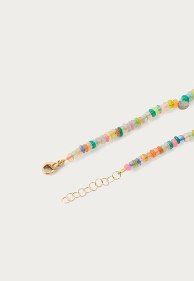 Daudzkrāsains apaļo pērlīšu aproce ar zelta lobstera sprādzi un regulējamu ķēdīti uz balta fona.