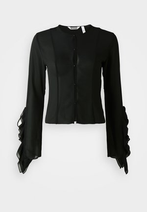 Black blouse made of smooth fabric, featuring a high neckline, button front, and long sleeves with ruffled accents at the cuffs.