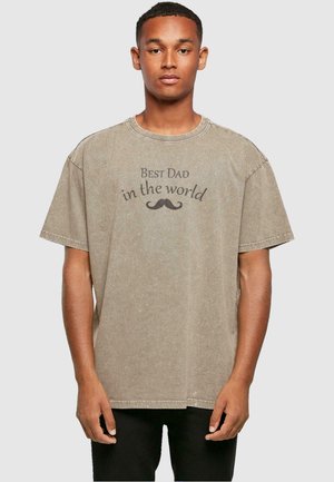 Beige cotton t-shirt featuring a crew neck, short sleeves, and the text "Best Dad in the world" with a mustache graphic in dark brown.