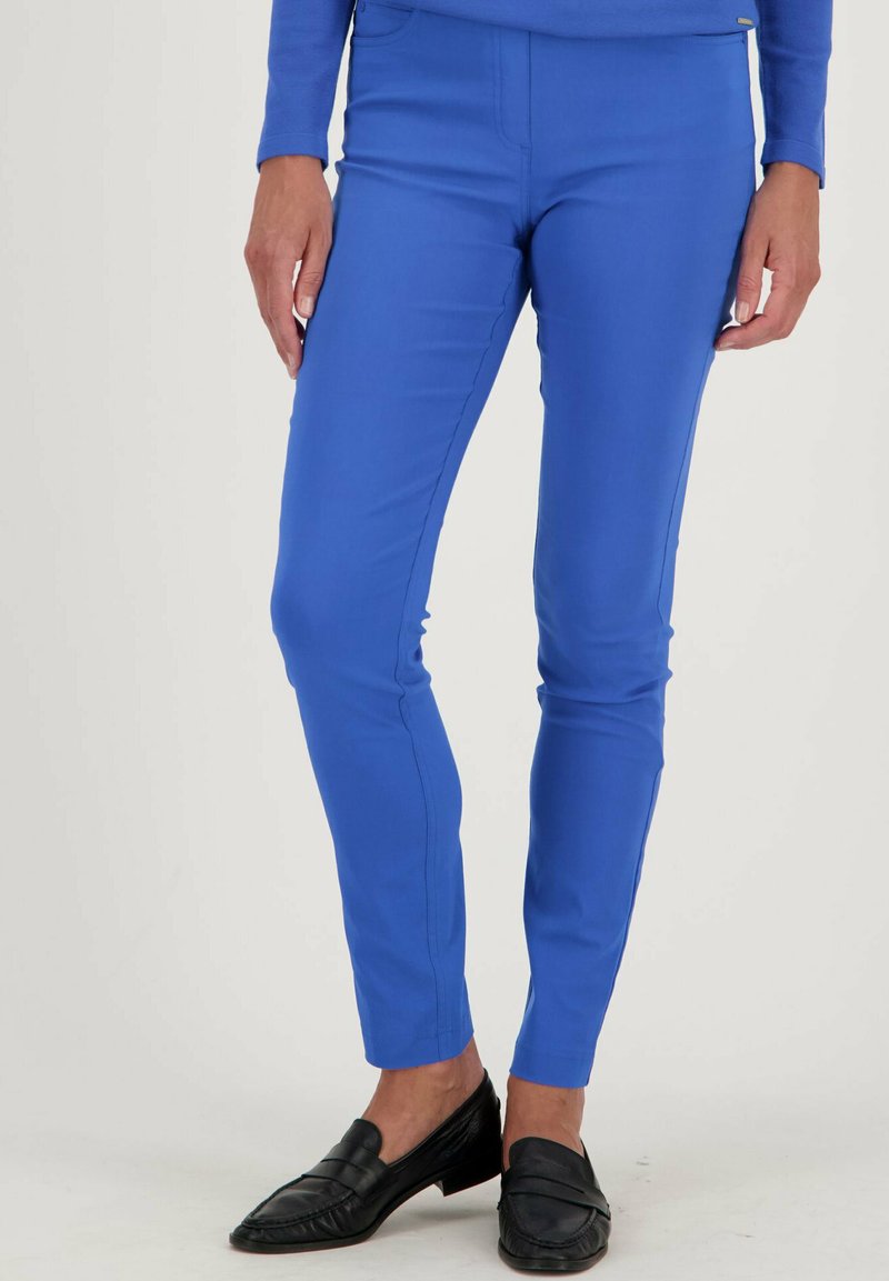 Blauwe stretchbroek met een slim fit, voorzien van een vlakke voorkant, een gladde textuur en een standaard tailleband. Gepaard met zwarte instappers.