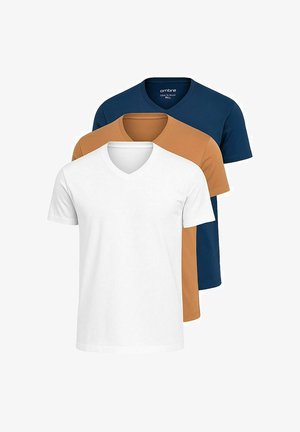Marineblå v-hals t-shirt parret med hvide tætsiddende bukser og hvide sneakers. T-shirten har en glat bomuldsstruktur, og bukserne har elastiske manchetter.