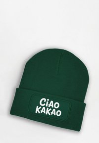 Green knitted beanie with a ribbed texture and folded cuff featuring a white rectangular patch with the text "Ciao Kakao."